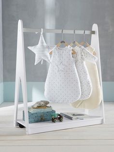 three baby's clothes hanging on a rack