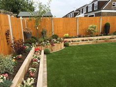 a garden with grass and flowers in the center, next to a fenced area