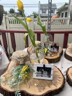 a table topped with vases filled with flowers next to two small wooden stumps