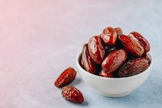 a white bowl filled with raisins sitting on top of a blue tablecloth