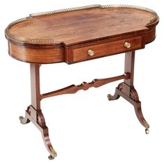 a wooden table with two drawers on one side and an ornate design on the other