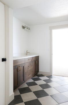 a bathroom with black and white checkered flooring next to an open sliding glass door