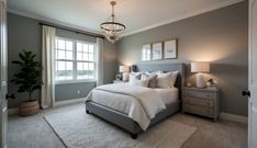 a bedroom with gray walls and white bedding in the center, along with a chandelier