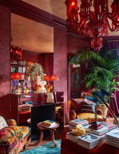 a living room filled with lots of furniture and a chandelier hanging from the ceiling