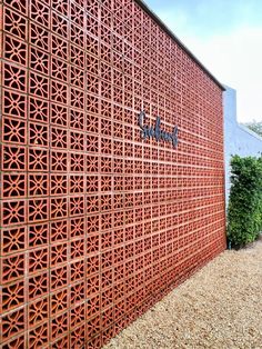 the side of a building with a large red lattice pattern on it's wall