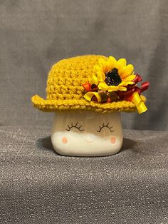 a yellow crocheted hat with sunflowers on it's brim