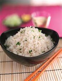 a black bowl filled with rice next to chopsticks