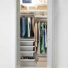 an organized closet with clothes hanging on shelves and baskets in the bottom drawer, next to a rug