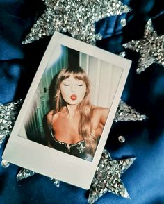 a polaroid photo of a woman with long hair and red lips on a blue background