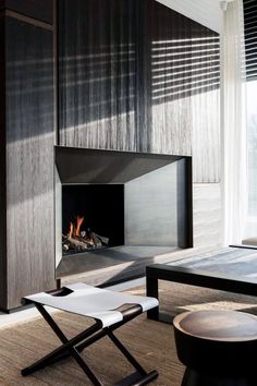 a living room with a fire place next to a table and chair in front of a window