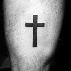 a man's leg with a cross tattoo on the side of his calf, which is black and white