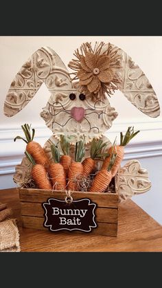 a wooden box filled with carrots sitting on top of a table next to a sign