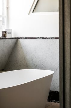 a white bath tub sitting next to a window