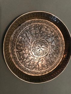 a metal plate with writing on it sitting on top of a gray countertop next to a wall