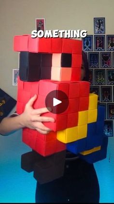 someone is holding up a giant lego block