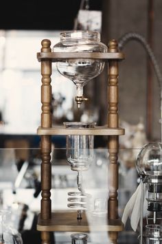 an old fashioned coffee grinder on display in a store or office setting with other items