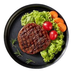 a steak and vegetables on a black plate