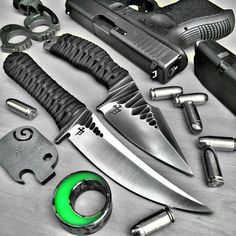 several different types of knifes and knives on a table with green light in the middle