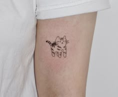 a small cat tattoo on the left arm