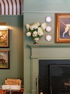 a living room filled with furniture and pictures on the wall next to a fire place