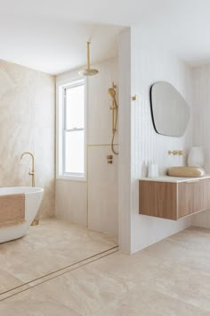 a bathroom with a bathtub, sink and large mirror on the wall above it