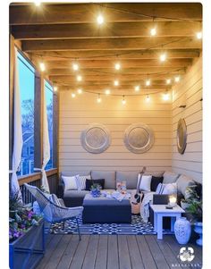 an outdoor living area with patio furniture and string lights on the ceiling, along with potted plants