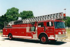 a red fire truck is parked on the side of the road in front of some trees