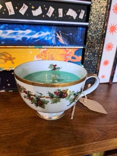 a tea cup with holly decorations on it