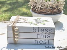 a stack of books sitting on top of a table next to a potted plant