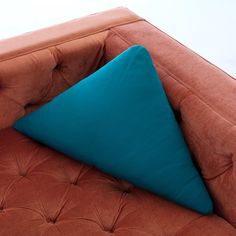 a brown couch with a blue pillow on it