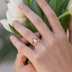 a woman's hand holding a bouquet of flowers with a diamond ring on it