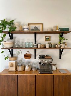 the shelves are filled with pots, bowls and other kitchen utensils on them