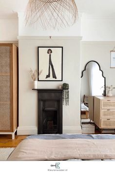 a living room with a fireplace, mirror and wicker decor on the wall above it