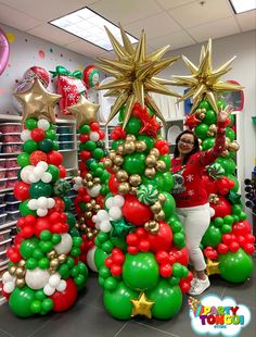 a woman standing next to christmas trees in an office