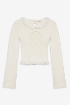 Inspired by vintage motifs, the Lyon white knit top shows off an inset rose cameo at the bust. This slightly cropped sweater is crafted in a ribbed knit and features a high neck with a lace ruffled trim. Cream Knitted Tops, White Coquette Sweater, Vintage Motifs, White Knit Top, Perfect White Tee, Trim Fit, Silky Dress, Solid & Striped, Little White Dresses