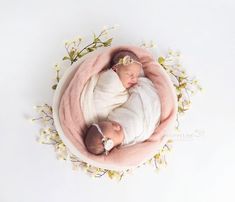 a newborn baby is wrapped in a pink blanket and laying on it's side