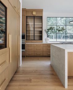 a large kitchen with wooden cabinets and an island countertop in front of a window