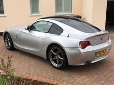 a silver sports car parked in front of a house