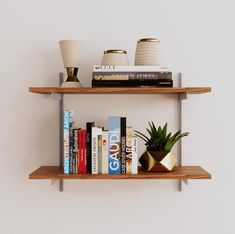 two wooden shelves with books and plants on them