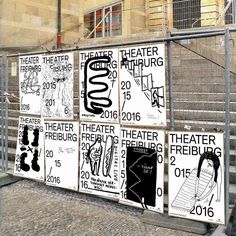 some posters are hanging on the side of a building near stairs and railings that have been decorated with black and white designs