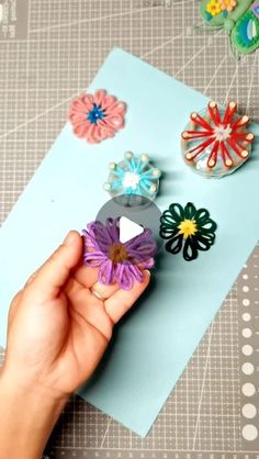 someone is holding some paper flowers on a piece of crafting material that they are made from