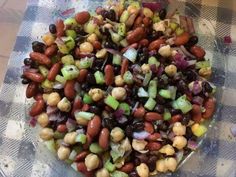 a bowl filled with beans, onions and celery on top of a checkered table cloth