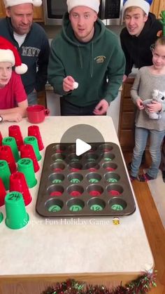 a group of people standing around a table with cupcakes in front of them