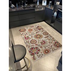 a kitchen area with a rug on the floor and counter top in front of it