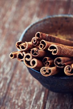 cinnamon sticks in a bowl on a wooden table