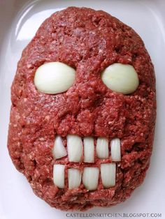 a close up of a meatball with teeth and eyes on a white plate in the shape of a skull