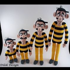 three knitted dolls are dressed in yellow and black striped outfits, one is holding the other's head