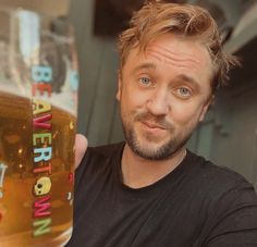 a man holding up a beer in his hand