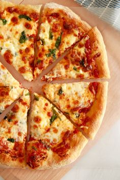 a sliced pizza sitting on top of a wooden cutting board