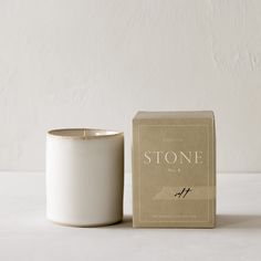 a white candle sitting next to a box